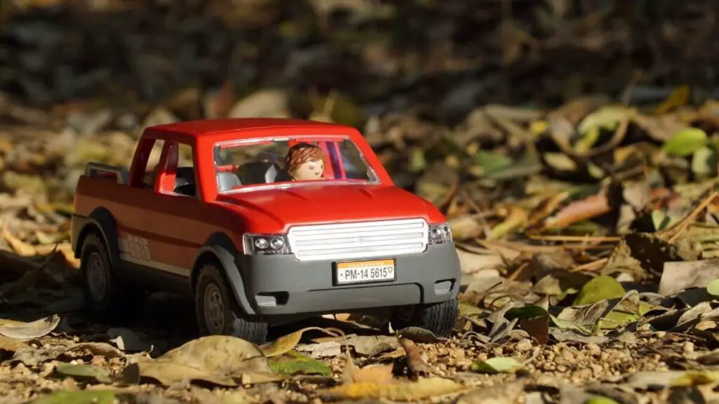 Playmobil Car with Minifigure driving a red pick up vehicle